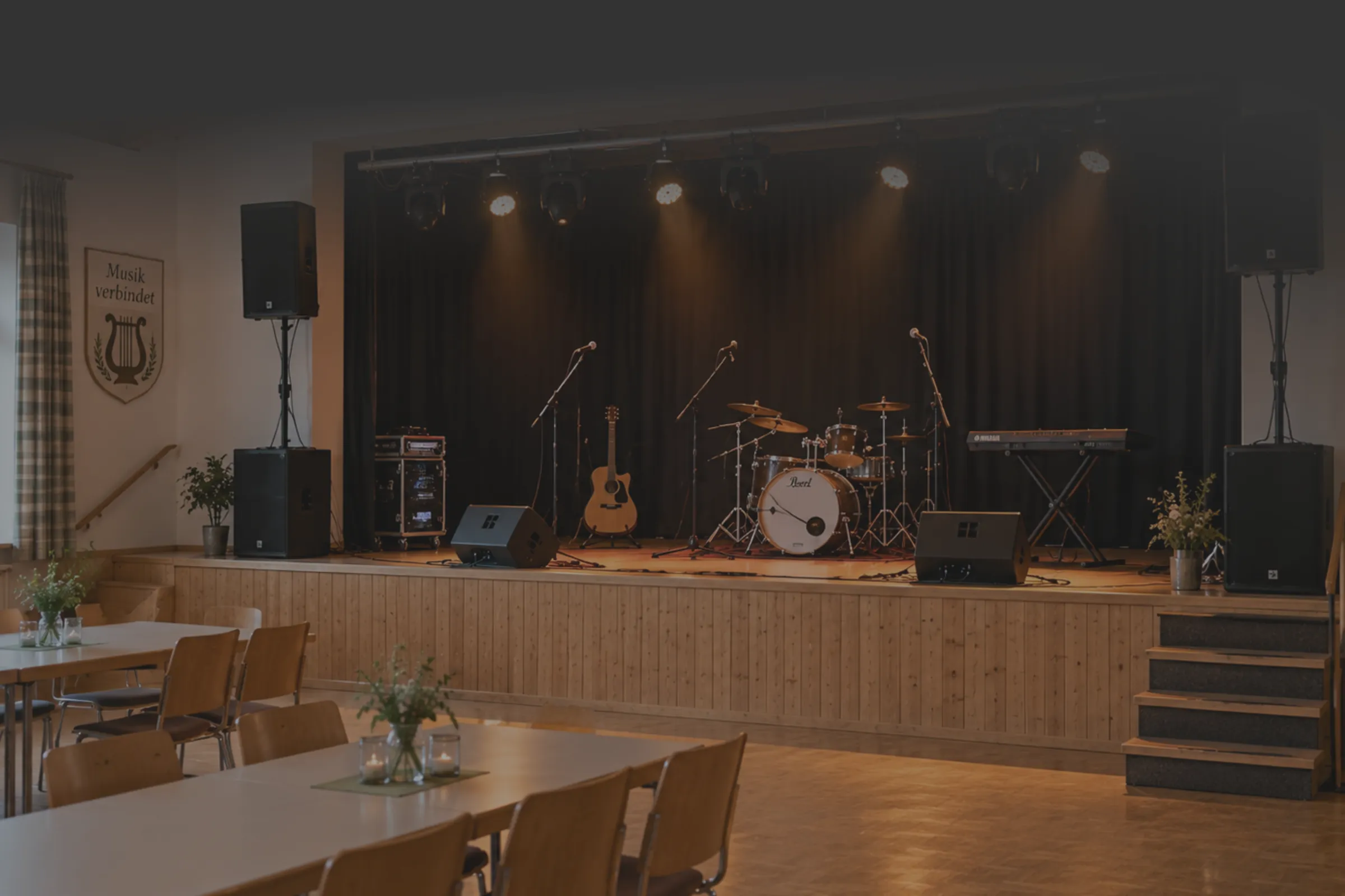 Veranstaltungssaal mit Bühne, Lautsprechern, Lichttechnik und Bestuhlung