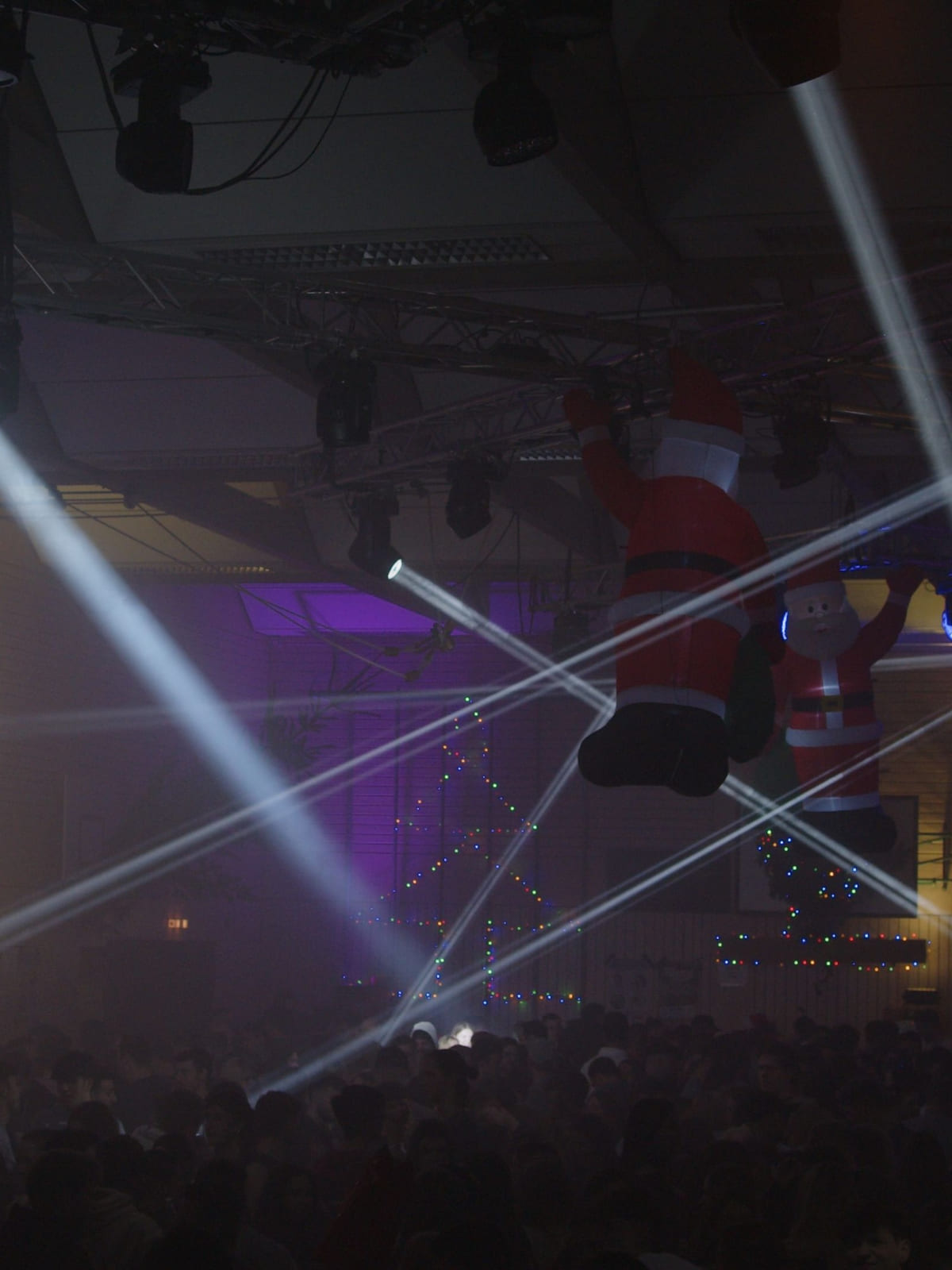 Halle mit kreuzenden Lichtstrahlen und hängenden Weihnachtsfiguren
