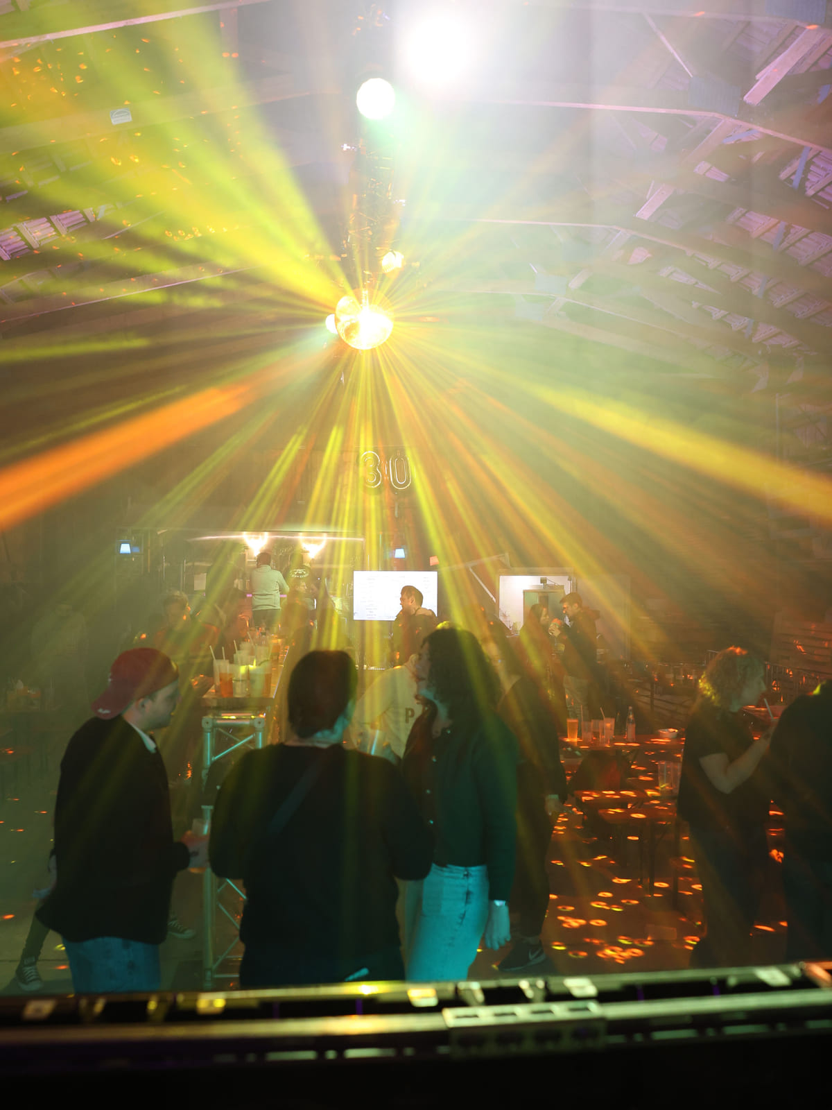 Party in einer Halle mit gelben und orangen Lichtstrahlen