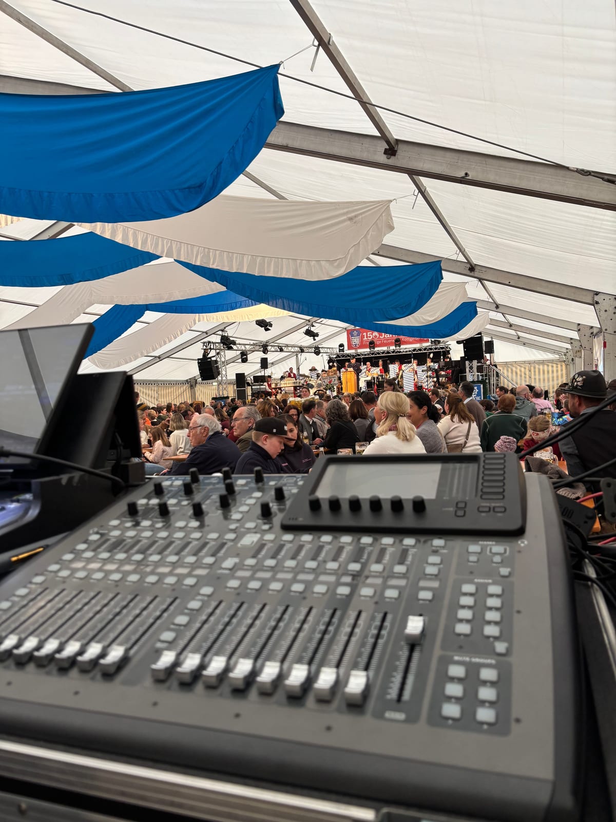 Blick vom Mischpult ins Festzelt mit Publikum, Bühne und Beschallung